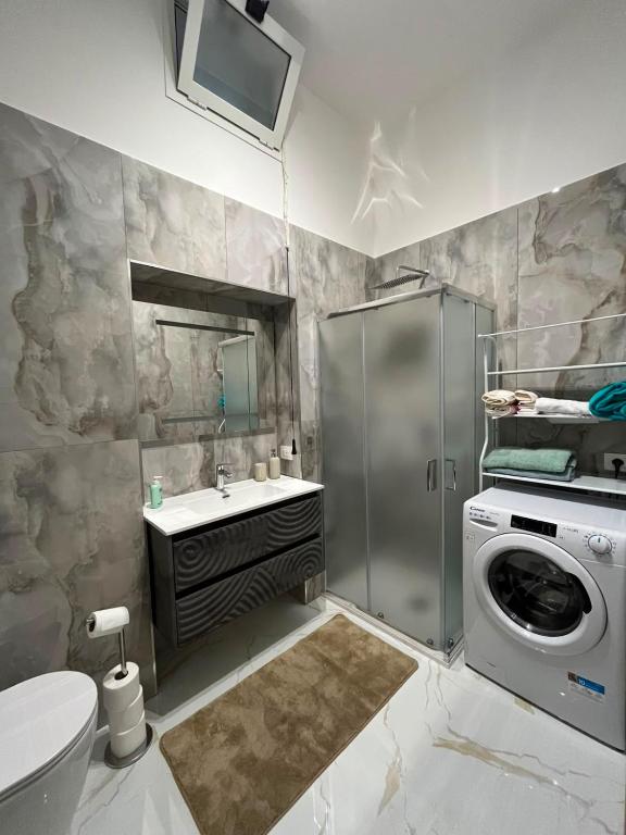 Bagno con box doccia, lavatrice e set di cortesia